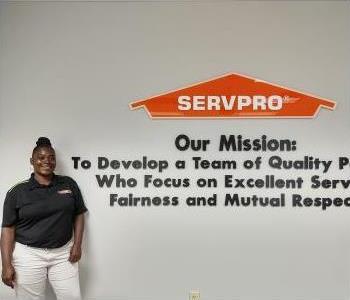 young black women with black hair in a bun wearing a black SERVPRO polo.