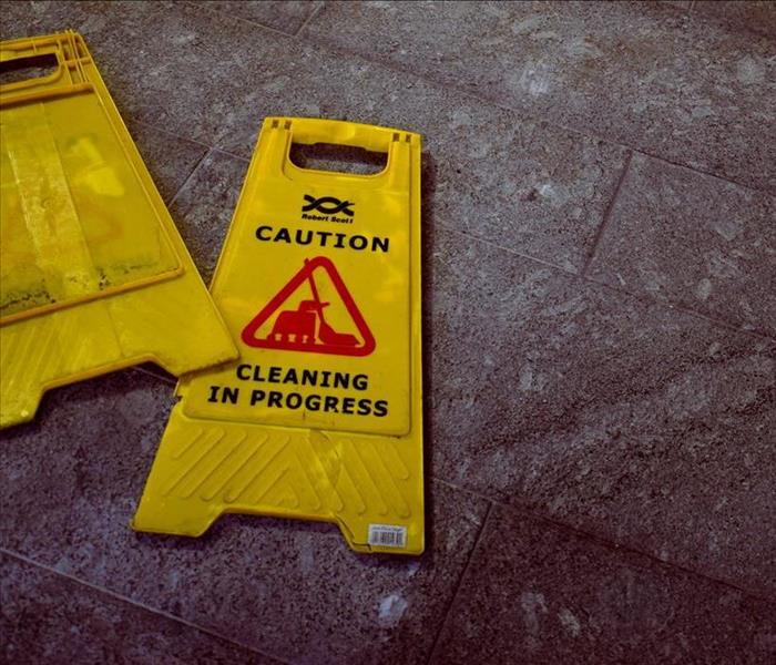 Two "Wet Floor" signs sitting on wet carpet