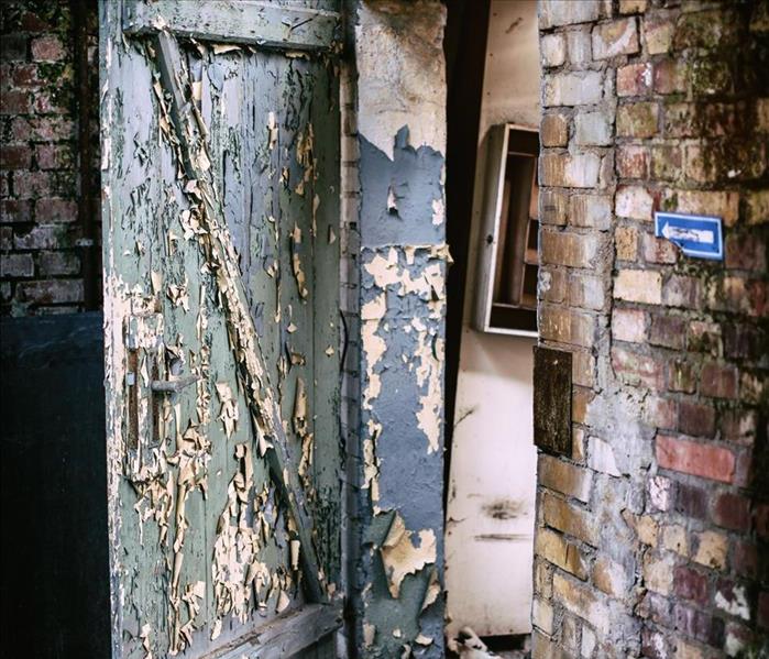 A door and walls with peeling paint and dirt and grime